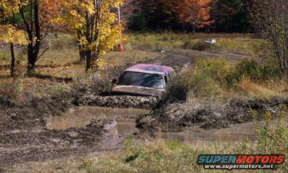 Pink SUV stuck deep in mud on a trail
