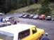 1976 Ford F-100 - A yellow SUV with a white top is parked in a lot with several other vehicles, including SUVs and trucks.
