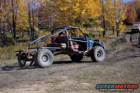 Modified off-road vehicle with roll cage, exposed frame, and large tires