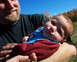 1979 Ford Bronco - A man holds a baby outdoors with autumn trees in the background.