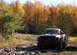 1979 Ford Bronco - A pickup truck navigates a muddy path during autumn, with colorful trees surrounding the scene.