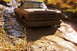 1979 Ford Bronco - A pickup truck navigates a challenging muddy path, its body heavily coated in thick mud.