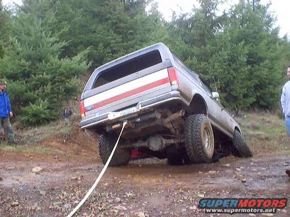 Ford Bronco stuck in mud, being pulled by a rope