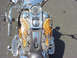 1999 Harley-Davidson Fat Boy - A motorcycle's front view showcases a custom paint job angel wings on the gas tank, complemented by shiny chrome accents.