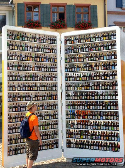 guy looking at a giant open book filled with beer bottles