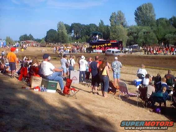 Mud run event with spectators and a truck in the background