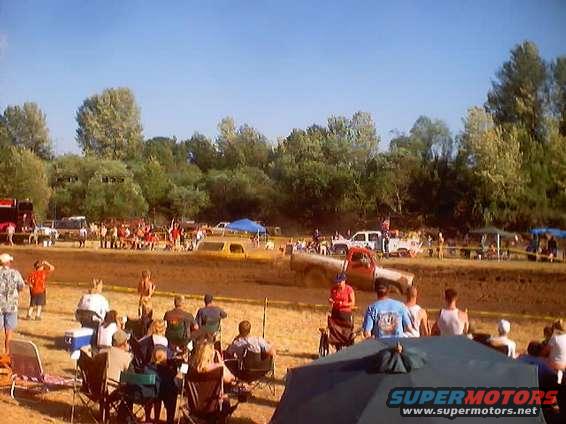 people watching trucks in a mud pit