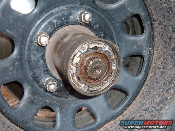 Close-up of a vehicle's wheel hub with lug nuts and a locking mechanism