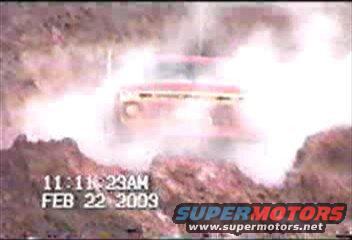 Truck obscured by dust cloud, timestamp 11:11:23 AM FEB 22 2009