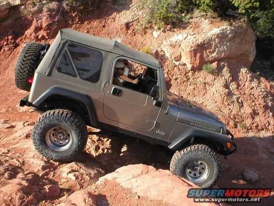 Gray Jeep Wrangler Rubicon off-roading on rocky terrain