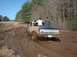 1978 Ford Bronco - A 1978 Ford F-Series pickup truck navigates a muddy track with two occupants in the cab.