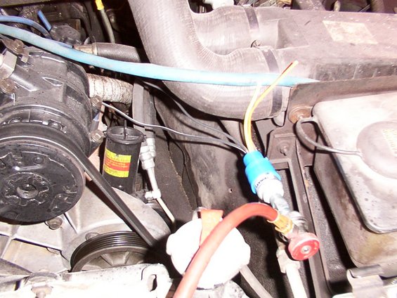 Close-up of AC system parts with hoses and gauges attached