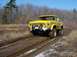 1978 Ford Bronco - A yellow 1978 Ford Bronco navigates a muddy track with large tires.