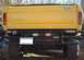 1978 Ford Bronco - Rear view of a yellow Ford truck, likely a 1979 model, a custom bumper and various stickers.
