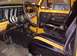 1978 Ford Bronco - The interior of a yellow Ford Bronco, black seats with yellow stripes and a visible floor mat with Ford branding.