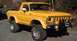 1978 Ford Bronco - A yellow 1978 Ford Bronco with a custom front bumper and off-road tires is parked outdoors.