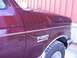 1988 Ford C-350 (Centurion Conversions) - The side view of a maroon Ford F-350 XLT Lariat truck shows its fender and part of the hood.