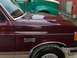1988 Ford C-350 (Centurion Conversions) - A maroon Ford F-250 pickup truck is parked next to a green semi-truck.
