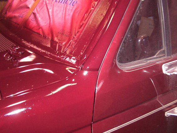 Red vehicle hood and windshield corner with red protective covering