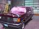 1988 Ford C-350 (Centurion Conversions) - Maroon Ford F-Series truck with pink protective covering on windshield and roof, parked indoors.