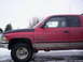 1989 Chevrolet Blazer - Side view of a red Dodge Ram 1500 V8 pickup truck in snowy conditions.