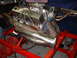 1969 Ford Mustang - A V8 engine is mounted on a red stand, chrome valve covers and custom exhaust headers.