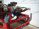1969 Ford Mustang - Engine assembly mounted on a red stand, chrome headers and an air filter, in front of a garage door.
