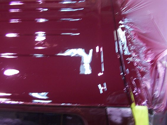 Maroon roof with reflections, part of a vehicle