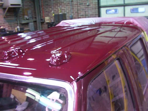 red truck roof with two clearance lights and plastic sheeting over the back