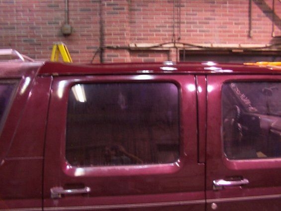 Maroon van side view, showing tinted windows and chrome door handles