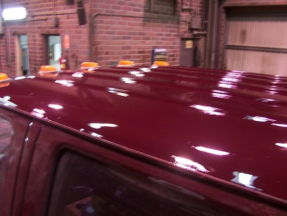 Red truck roof with multiple amber lights. Interior of a building with brick walls