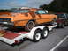 1970 Mercury Cyclone - Orange 1970 Mercury Cyclone coupe on a trailer, towed by a pickup truck. Significant rust is present on the body panels.
