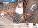 1970 Mercury Cyclone - Close-up view of a heavily rusted engine bay, showing the engine block, distributor, and various hoses and wires.