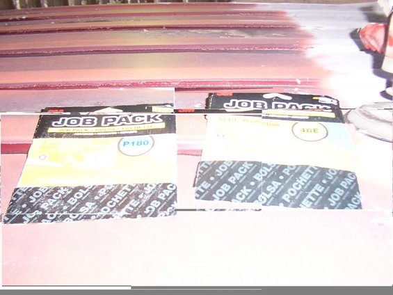 Two job pack sanding belts, one P180 and one 40E, on a red surface