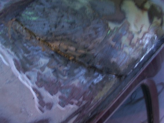 Vehicle roof panel with visible metal repair work and primer