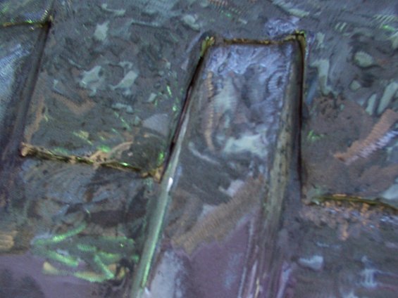 Close-up of textured, dark material with some reflective highlights