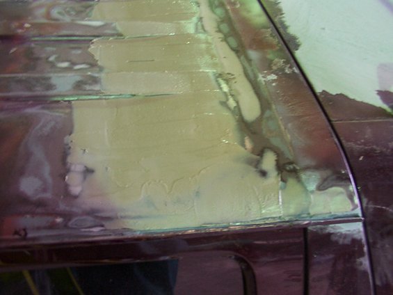 Close-up of body filler applied to a vehicle's roof panel seam