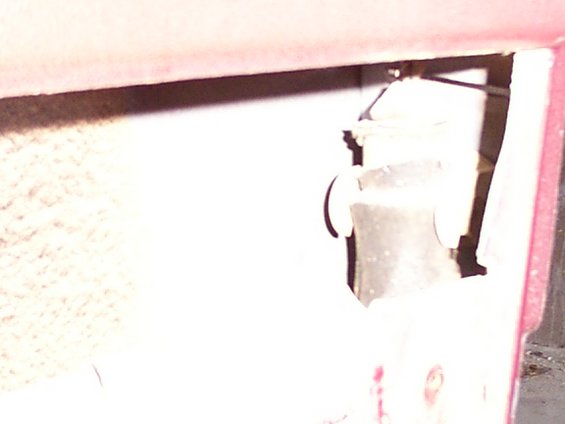 Close-up of a vehicle's interior door lock mechanism, showing metal components and wiring