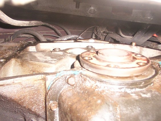 Close-up of a greasy transmission housing with a bolted flange