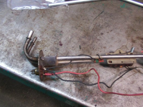 Fuel pump sender with metal tubes and electrical wires on a workbench