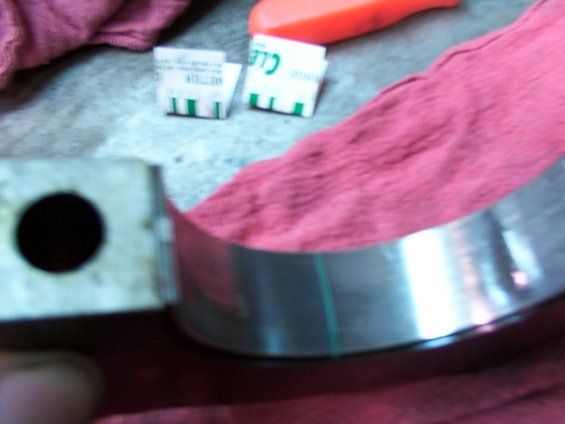 Engine bearing with green markings and a hole, on a red cloth
