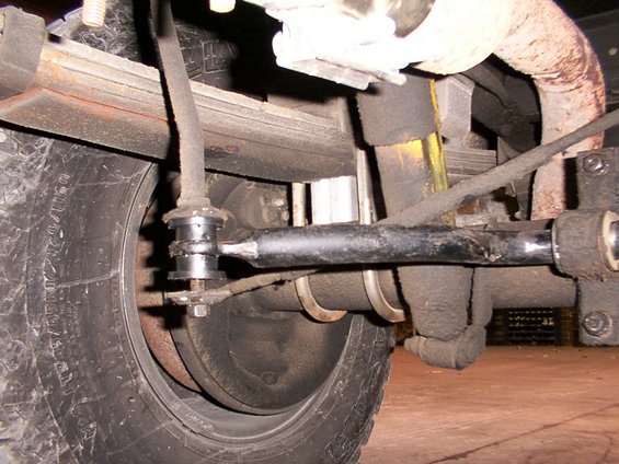 Rear suspension part, sway bar link, leaf spring, shock absorber, and tire
