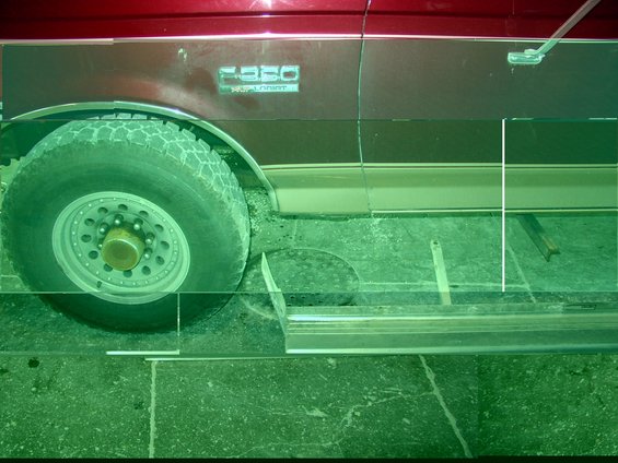 Side view of a red Ford F-350 truck with a chrome running board and a large tire