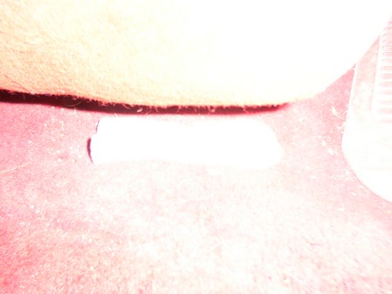 Close-up of vehicle's red carpet and a piece of white trim