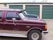 1988 Ford C-350 (Centurion Conversions) - Maroon extended cab pickup truck with F250 badging, seen parked next to another truck in front of storage units.