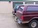 1988 Ford C-350 (Centurion Conversions) - Two Ford Bronco SUVs are parked side-by-side in front of storage unit doors.