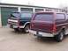 1988 Ford C-350 (Centurion Conversions) - Two Ford Broncos parked in front of storage units, one maroon and one dark blue.