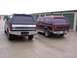 1988 Ford C-350 (Centurion Conversions) - Two Ford Bronco SUVs are parked side-by-side in front of storage unit doors.