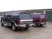 1988 Ford C-350 (Centurion Conversions) - Two Ford Broncos are parked in front of storage units, viewed from the rear.