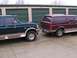 1988 Ford C-350 (Centurion Conversions) - Two Ford trucks, a green F-Series and a maroon Bronco SUV, are parked side-by-side in front of storage unit doors.